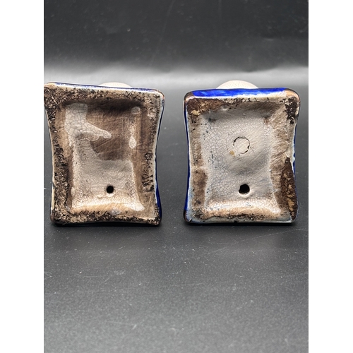 115 - This is a pair of Staffordshire pottery cat figurines seated on blue cushions. These items are colle... 