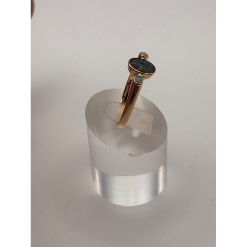 38 - 14ct yellow gold dark green gem flanked by smaller opal gemstones. 
Weighs 4.36g
Size r
