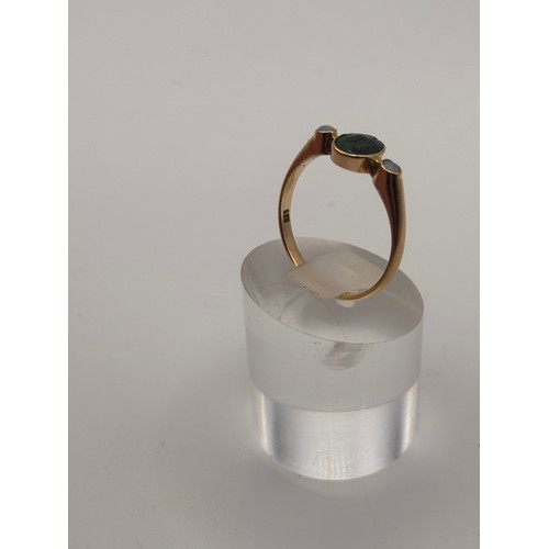 38 - 14ct yellow gold dark green gem flanked by smaller opal gemstones. 
Weighs 4.36g
Size r