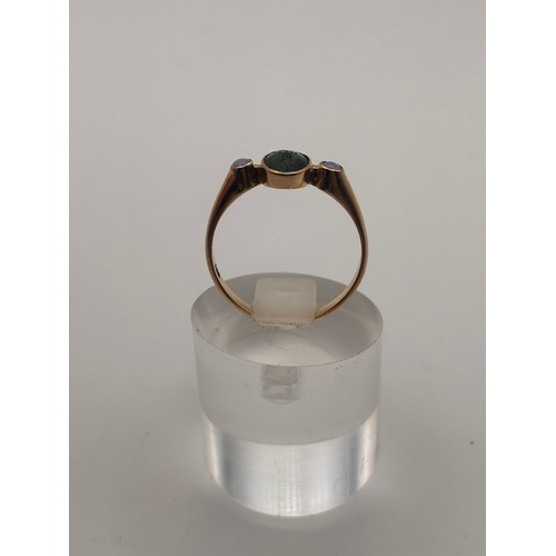 38 - 14ct yellow gold dark green gem flanked by smaller opal gemstones. 
Weighs 4.36g
Size r