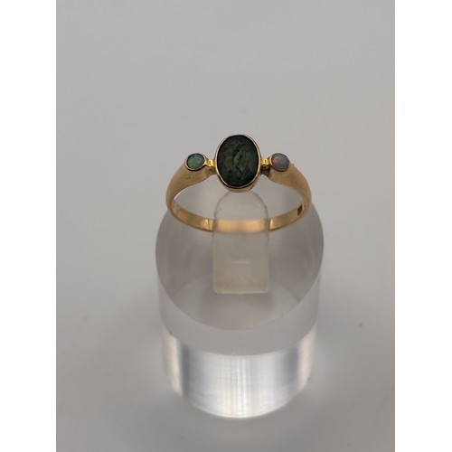38 - 14ct yellow gold dark green gem flanked by smaller opal gemstones. 
Weighs 4.36g
Size r