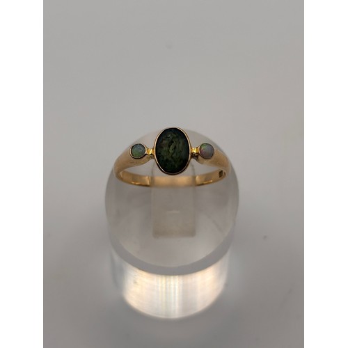 38 - 14ct yellow gold dark green gem flanked by smaller opal gemstones. 
Weighs 4.36g
Size r