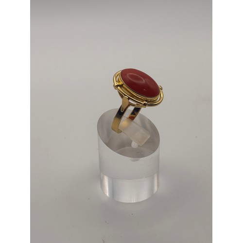 35 - 18ct yellow gold cabochan cut red coral in ornate setting.
Weighs 6.67g

Size p/q