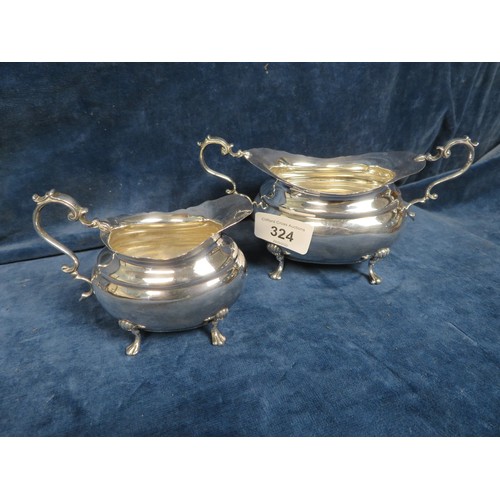 324 - A silver two handled sugar basin on four splayed shell feet and similar cream jug hallmarked Sheffie... 