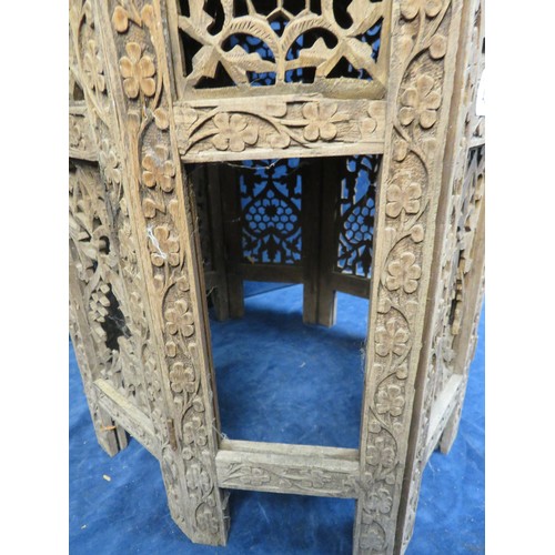 438 - An Octagonal side table with ornately carved eastern style floral decoration A/F.