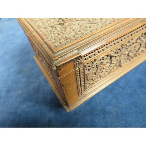 467 - An ornately carved Sandal Wood box, 48cm long x 10cm wide and 8cm high with key, some missing beadin... 