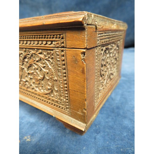 467 - An ornately carved Sandal Wood box, 48cm long x 10cm wide and 8cm high with key, some missing beadin... 