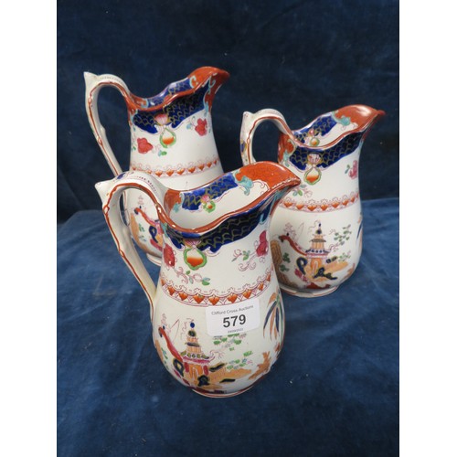 579 - A set of 3 graduated pottery jugs with oriental decoration A/F.