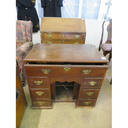 750 - An antique oak knee hole desk with sliding drawer and fitted interior with six small drawers. (Needs... 