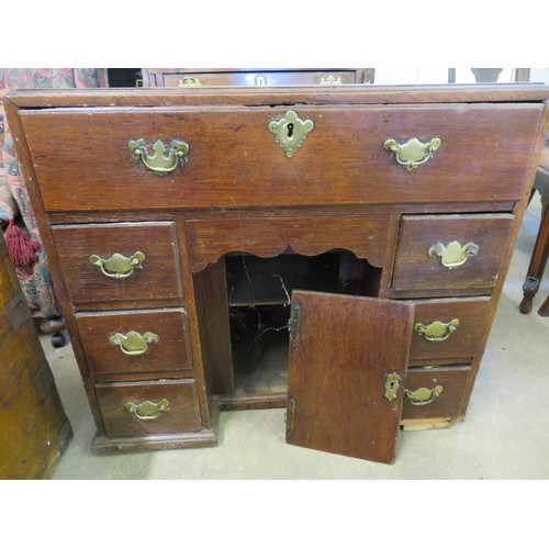 750 - An antique oak knee hole desk with sliding drawer and fitted interior with six small drawers. (Needs... 