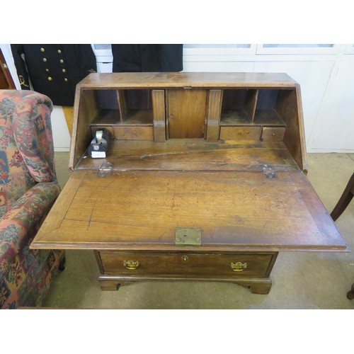 751 - An antique mahogany bureau desk with fitted interior  and 4 drawers on bracket feet and brass drop h... 