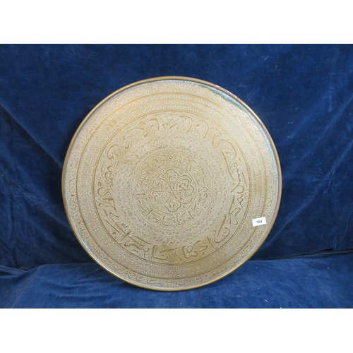 754 - An ornate brass circular table top with elaborate eastern style decoration 59.5cm diameter. (No legs... 