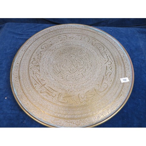 754 - An ornate brass circular table top with elaborate eastern style decoration 59.5cm diameter. (No legs... 