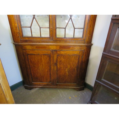 758 - An antique oak corner cupboard with glazed doors and 2 shelves and cupboard under on bracket feet wi... 