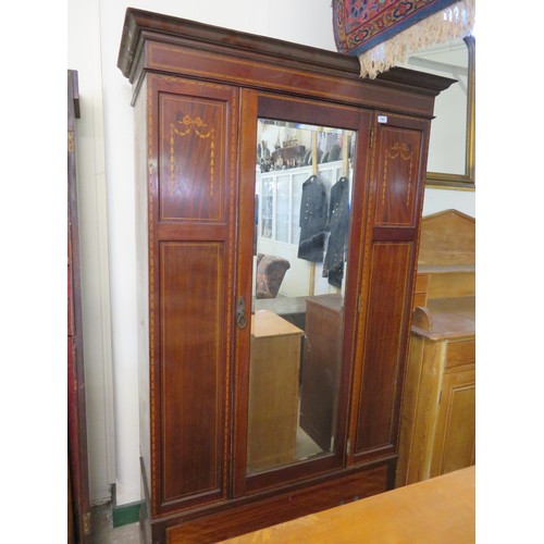 766 - An Edwardian Sheraton style wardrobe, Druce & Co, London with central door having full length bevel ... 