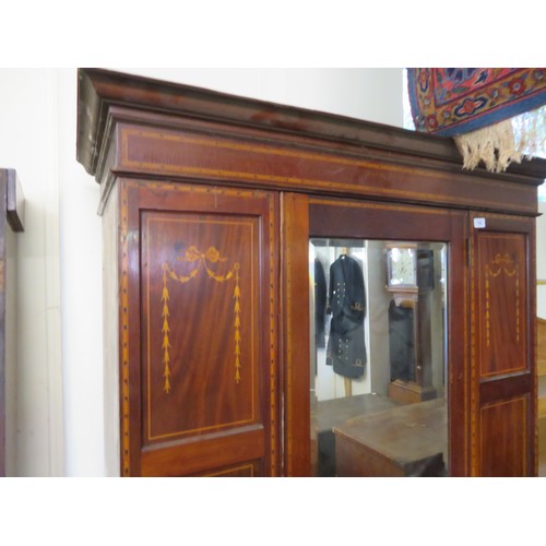 766 - An Edwardian Sheraton style wardrobe, Druce & Co, London with central door having full length bevel ... 