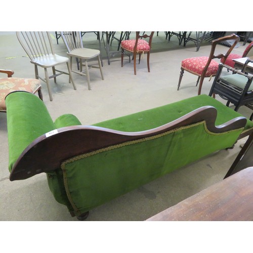 770 - An antique mahogany chaise longue with carved grape decoration on turned legs having green upholster... 