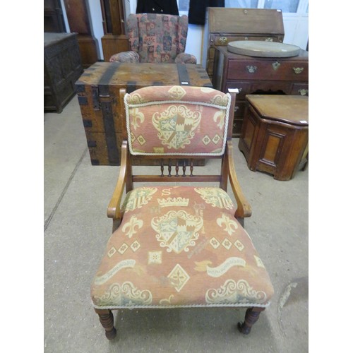 771 - A small mahogany framed and inlaid nursing chair with padded and spindle back on turned legs.