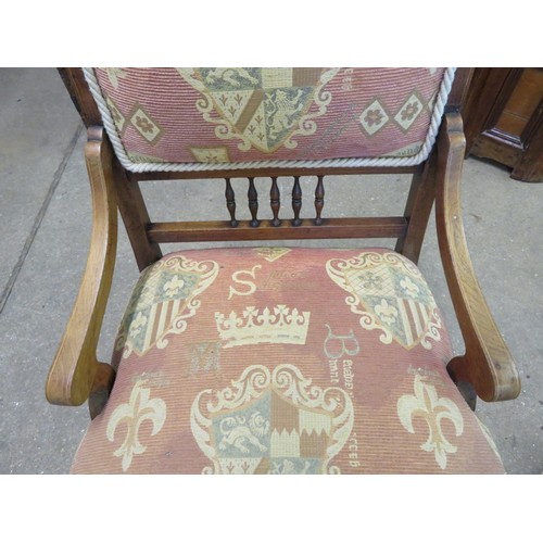 771 - A small mahogany framed and inlaid nursing chair with padded and spindle back on turned legs.