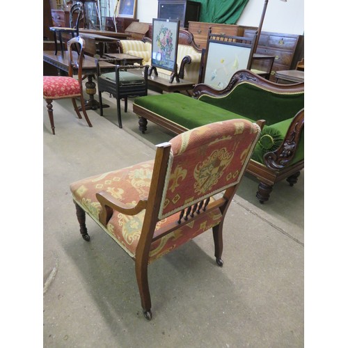 771 - A small mahogany framed and inlaid nursing chair with padded and spindle back on turned legs.