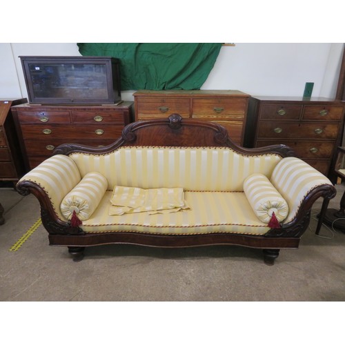 778 - An antique mahogany sofa with carved decoration and scroll arms upholstered in gold striped material... 