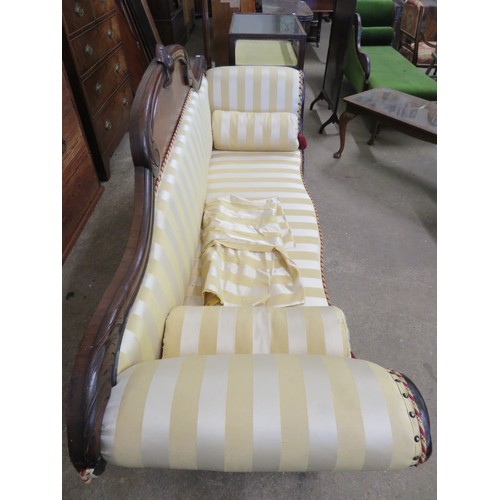 778 - An antique mahogany sofa with carved decoration and scroll arms upholstered in gold striped material... 