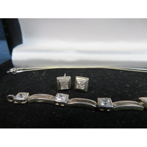 689 - A set of white metal and contemporary jewellery set with diamond effect stones and comprising bracel... 