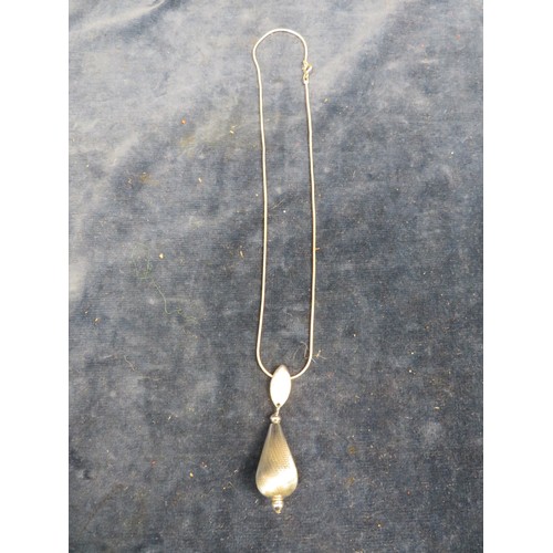 695 - A white metal pendant and chain.