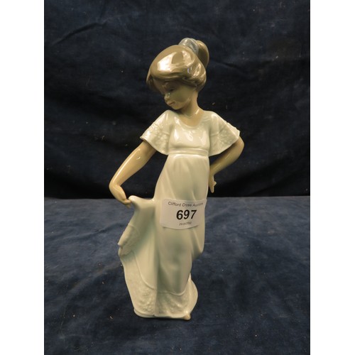 697 - A Nao figurine of a girl dressed in white standing in a curtsey pose.