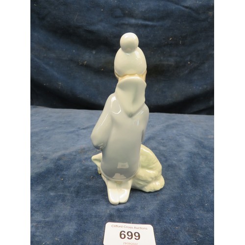 699 - A Lladro figurine of a boy with a lamb on his knees.