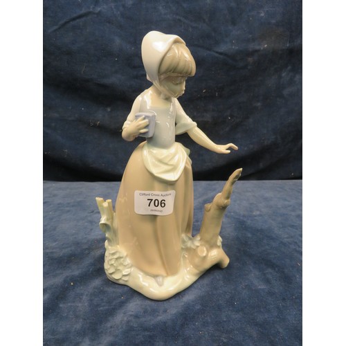 706 - A Nao figurine of a girl holding a parcel.