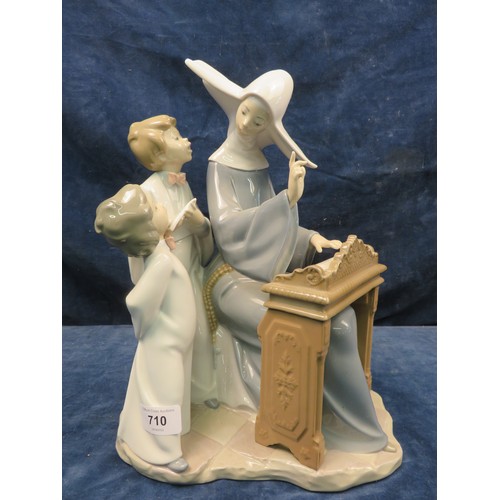 710 - A Lladro figurine of a nun with 2 choir boys.