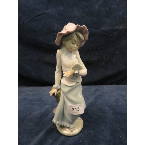 713 - A Nao figurine of a girl with a dove in her hand.