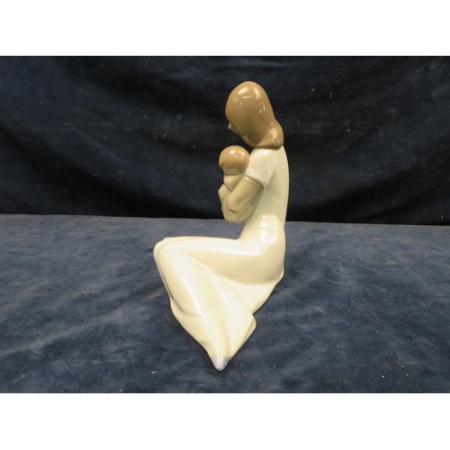 721 - A Nao figurine of a mother holding a sleeping child in her arms.