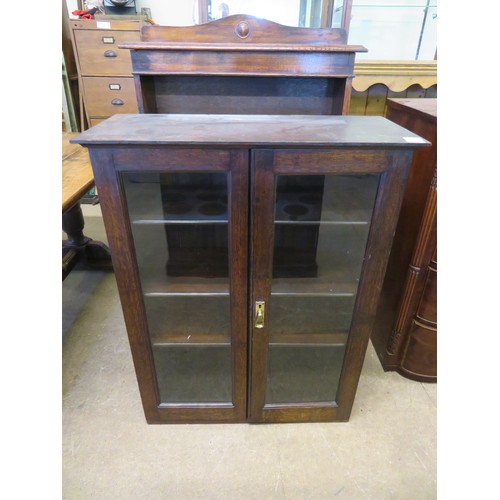 811 - A vintage oak cupboard with glazed doors and 3 adjustable shelves.