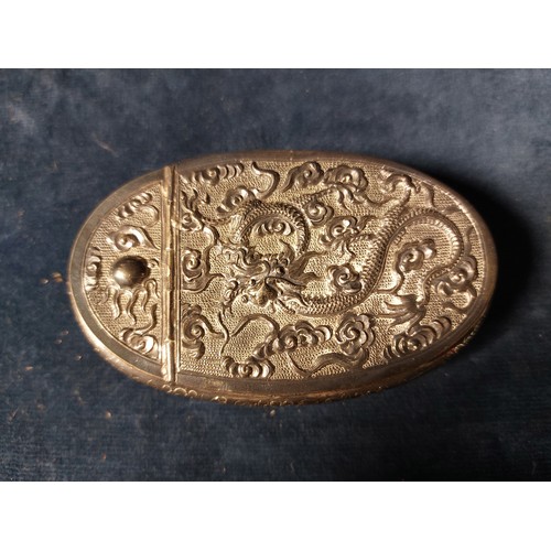 190 - An Oriental hinged white metal trinket box with embossed dragon design to the lid and foliate and ba... 