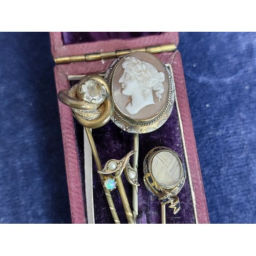 255 - Four vintage hat pins.