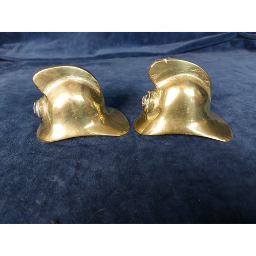 260 - Two small brass decorative firefighters helmets, each inset with a metal button.