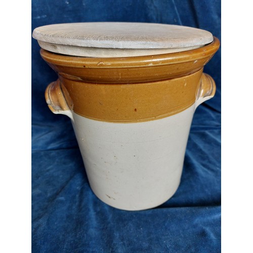 367 - A 2-tone stoneware pot having 2 applied handles and a hand-made wooden lid.