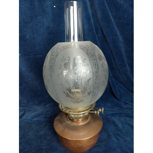 372 - A copper and brass oil lamp with chimney, having etched decorated glass globe shade.