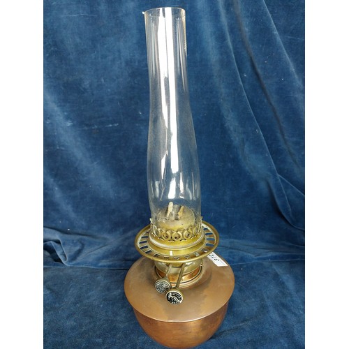 372 - A copper and brass oil lamp with chimney, having etched decorated glass globe shade.