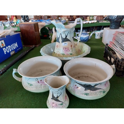 376 - A pottery wash bowl and jug, 2 chamber pots and toothbrush holder having swallow and floral decorati... 