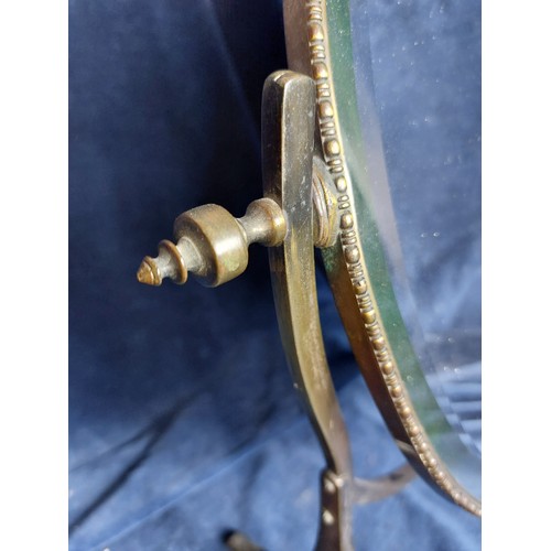 382 - A brass effect oval swing dressing table mirror, having bevel edge.