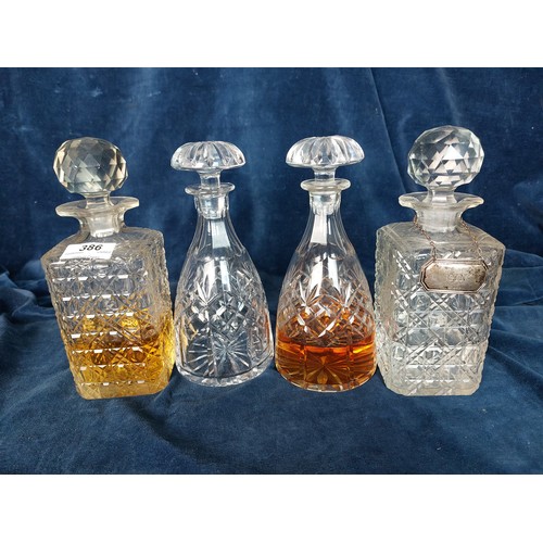 386 - A pair of cut glass square decanters, one having a metal gin label, together with a pair of cut glas... 