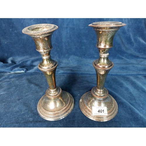 401 - A pair of silver-plated candlesticks, bases filled.