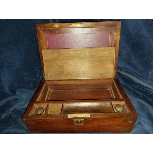 414 - An antique writing slope with brass banding corners, lock plate and a brass central insert with the ... 