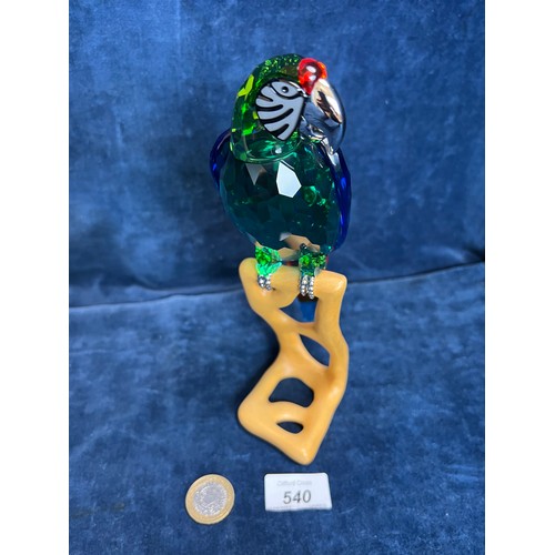 540 - A Swarovski Crystal figure of a Macaw on wooden stand.