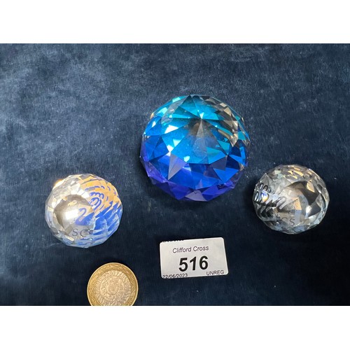 516 - Three Swarovski Crystal paperweights in various sizes.