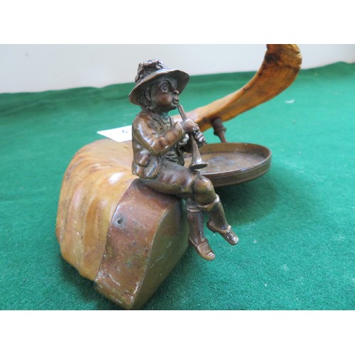 439 - A Bavarian ram's horn pipe rest mounted with figure playing pipe.