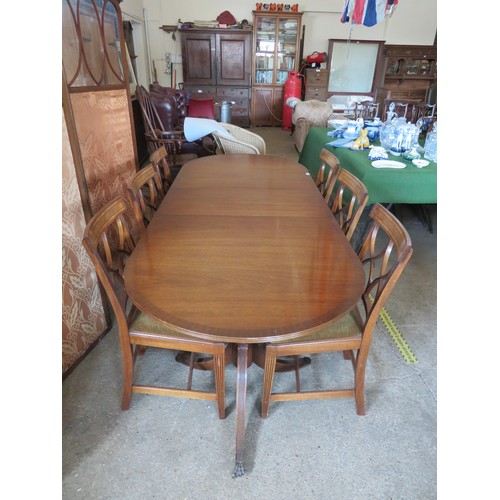 772 - An extending mahogany dining table and 6 chairs.  The table is on 2-pedestal bases with splayed legs... 